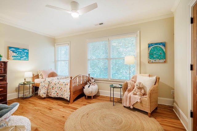 bedroom featuring multiple windows, light wood-style flooring, and ornamental molding