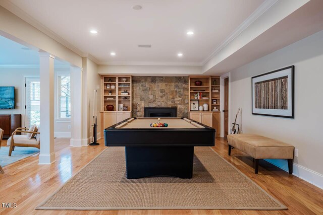 recreation room featuring crown molding, baseboards, light wood-type flooring, decorative columns, and recessed lighting