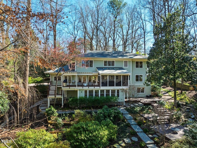 rear view of house with stairs and a sunroom