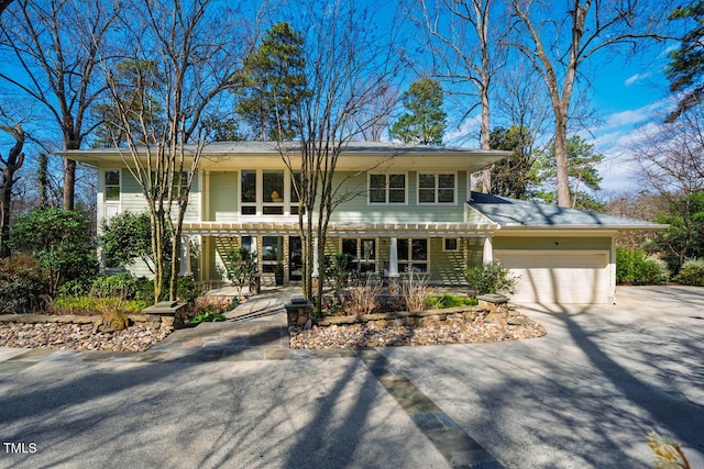 view of front facade with aphalt driveway, an attached garage, and a pergola