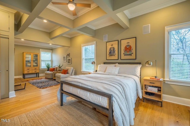 bedroom featuring beamed ceiling, multiple windows, light wood-type flooring, and baseboards