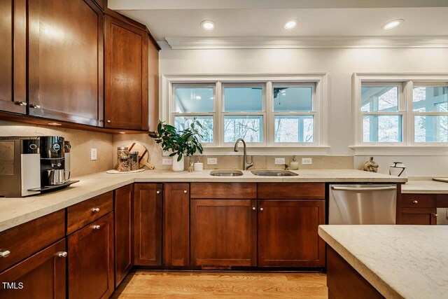 kitchen with dishwasher, crown molding, light wood-style floors, and a sink