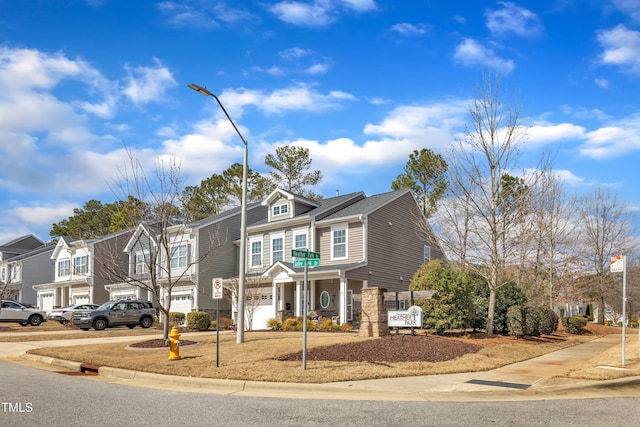 view of front of property featuring driveway, an attached garage, and a residential view