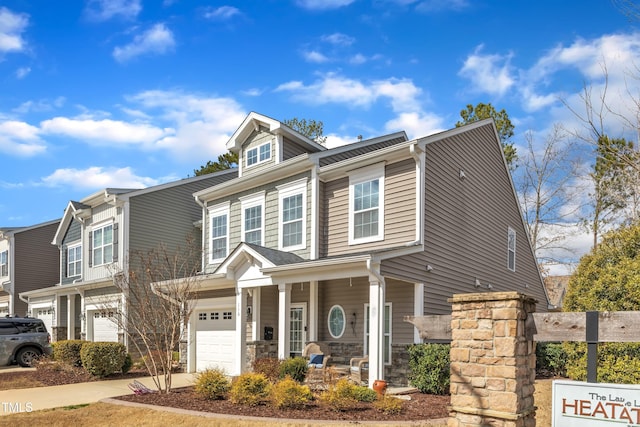 view of front facade featuring stone siding, covered porch, driveway, and an attached garage