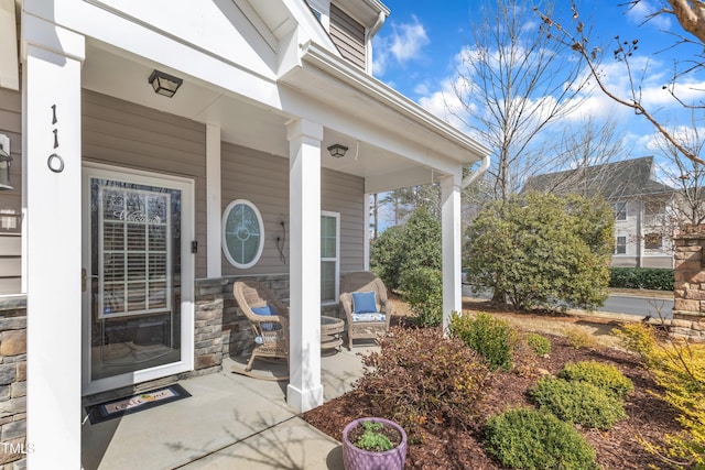 entrance to property with stone siding and a porch