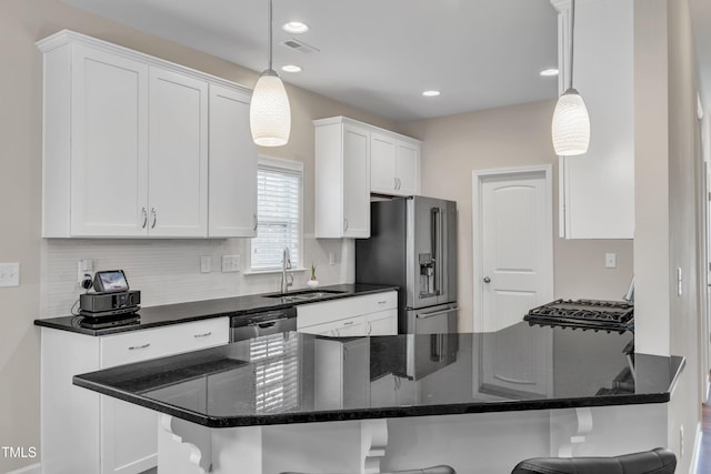 kitchen featuring a breakfast bar, white cabinets, a sink, and stainless steel refrigerator with ice dispenser