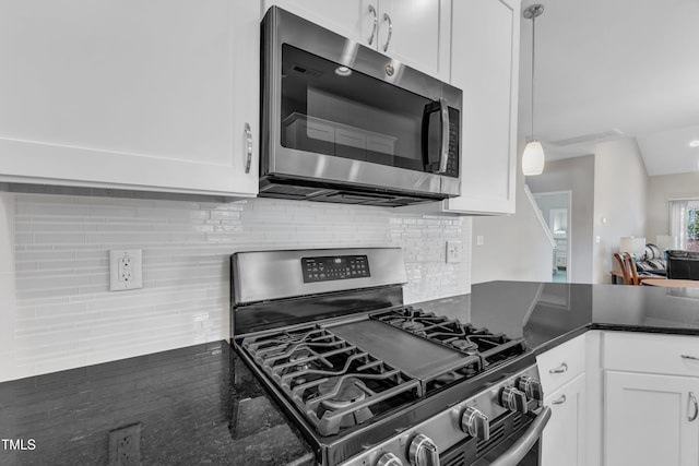 kitchen with lofted ceiling, white cabinetry, stainless steel appliances, and decorative backsplash