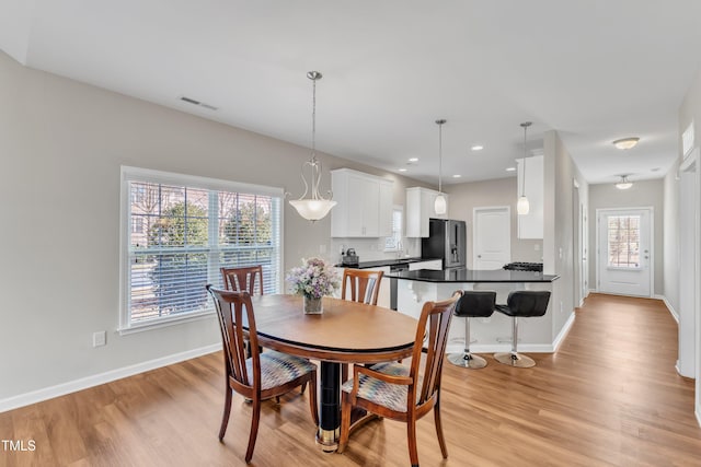 dining room featuring light wood-type flooring, visible vents, baseboards, and recessed lighting