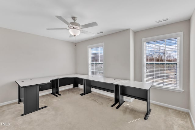 carpeted home office featuring a healthy amount of sunlight, visible vents, and baseboards