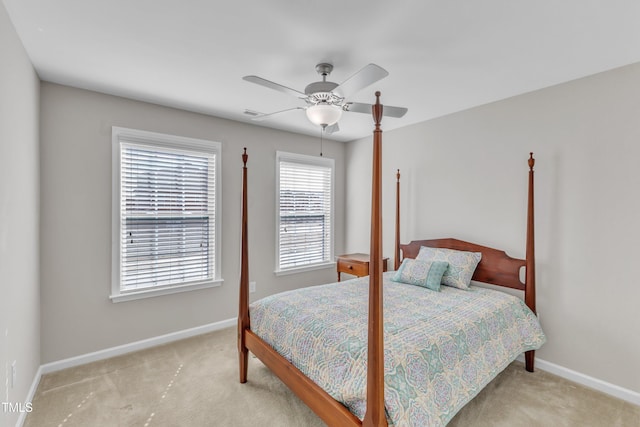 bedroom featuring a ceiling fan, light carpet, and baseboards