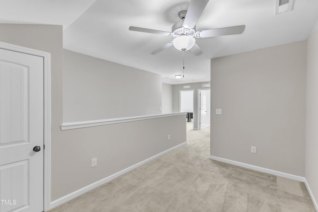 unfurnished room featuring light colored carpet, ceiling fan, visible vents, and baseboards