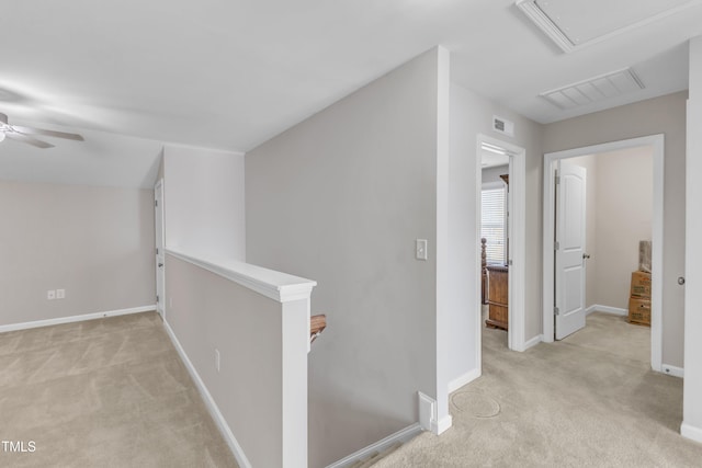 hall featuring light carpet, visible vents, and an upstairs landing