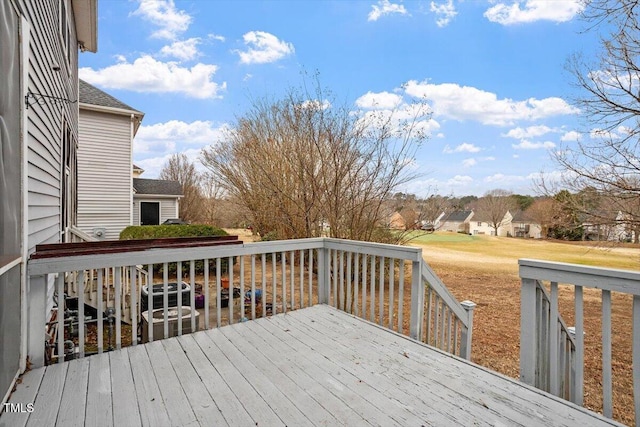 wooden deck featuring a lawn