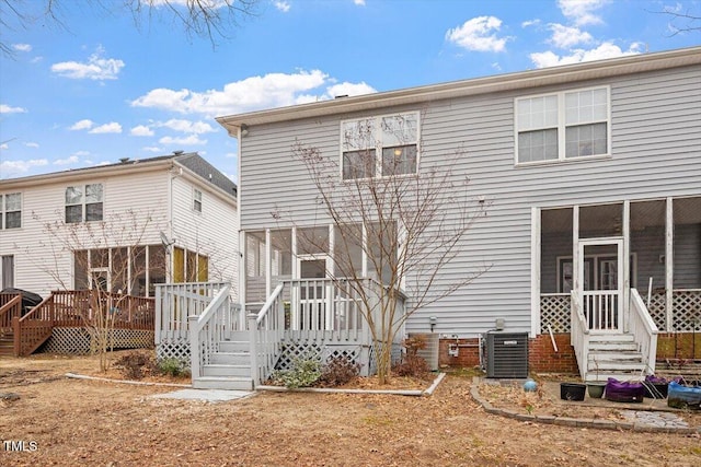 back of property with central air condition unit, a sunroom, and a wooden deck