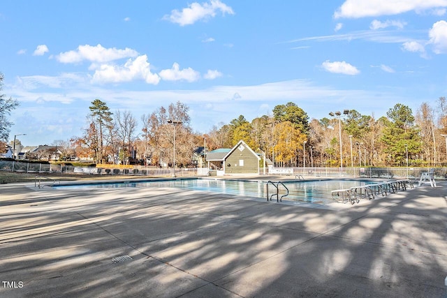 community pool with fence and a patio