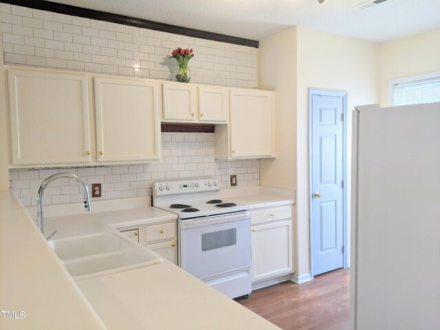 5321 Cog Hill Ct, Raleigh, NC 27604 - kitchen with white appliances, decorative backsplash, white cabinets, and light wood-style flooring