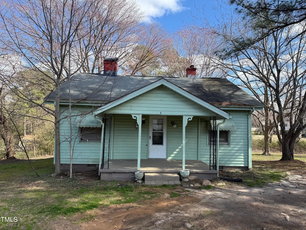 bungalow-style home with a chimney and a porch