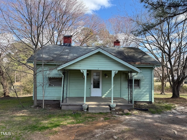 bungalow-style home with a chimney and a porch