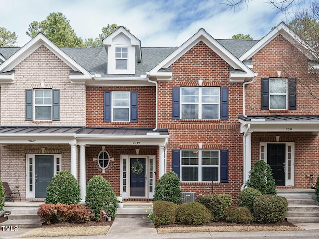 townhome / multi-family property with brick siding and a standing seam roof