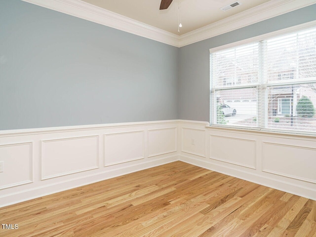 unfurnished room with visible vents, light wood-style flooring, crown molding, and ceiling fan