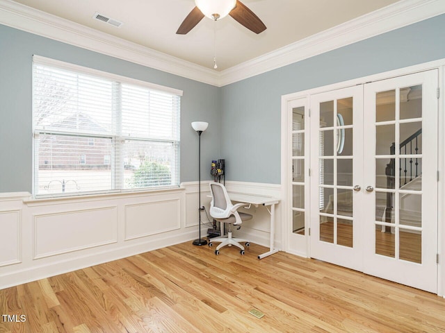 unfurnished office featuring visible vents, ornamental molding, french doors, wainscoting, and light wood-type flooring