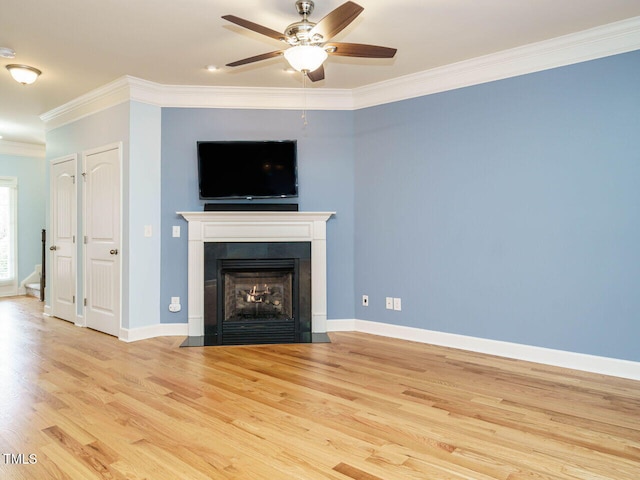 unfurnished living room with a fireplace with flush hearth, wood finished floors, crown molding, baseboards, and ceiling fan