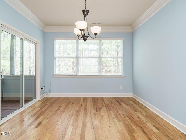 unfurnished dining area featuring baseboards, visible vents, light wood finished floors, and ornamental molding