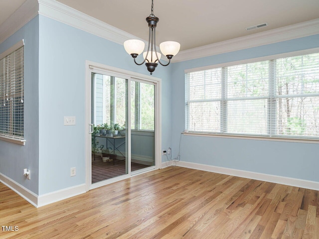 spare room featuring visible vents, baseboards, ornamental molding, and light wood-style flooring