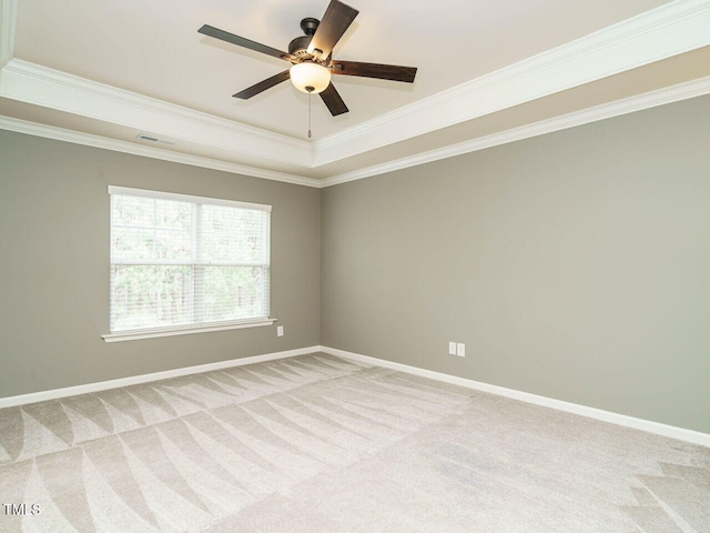 unfurnished room featuring baseboards, light colored carpet, ornamental molding, a raised ceiling, and a ceiling fan