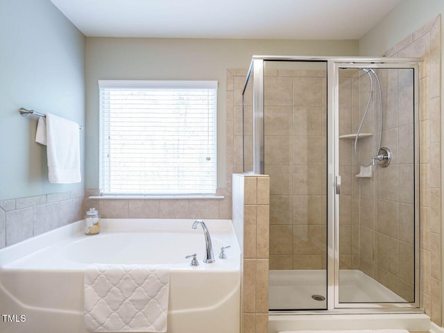 bathroom with a stall shower and a garden tub