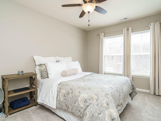 bedroom featuring light carpet, visible vents, a ceiling fan, and baseboards