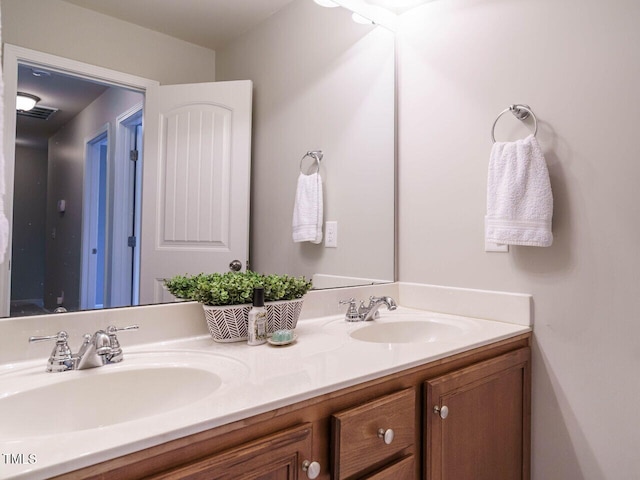 bathroom featuring double vanity, visible vents, and a sink