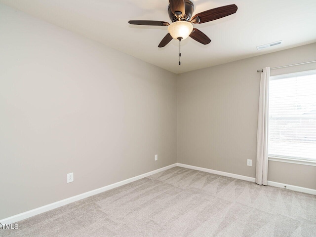 unfurnished room featuring visible vents, baseboards, light colored carpet, and a ceiling fan