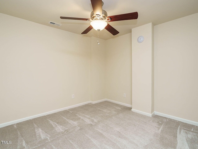 carpeted empty room with visible vents, a ceiling fan, and baseboards