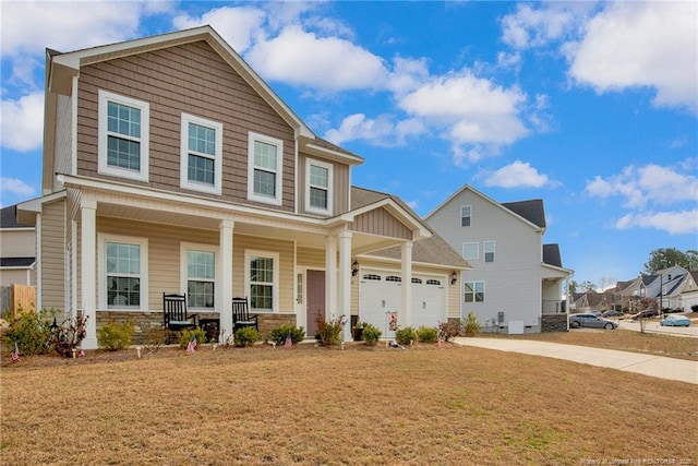 view of front of home with a garage, driveway, a porch, and a front lawn