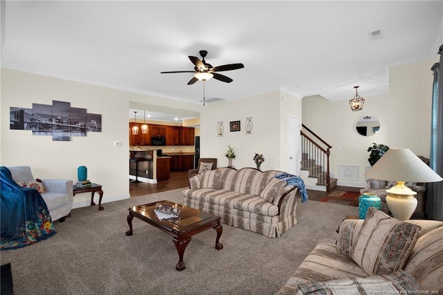 living area with visible vents, dark carpet, ornamental molding, baseboards, and stairs