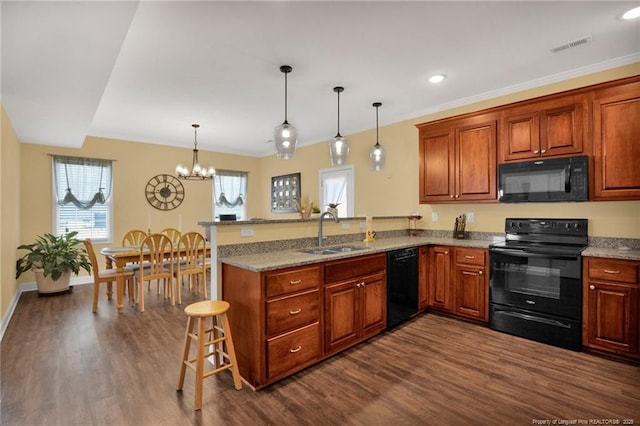 kitchen featuring black appliances, dark wood-type flooring, a peninsula, and a sink