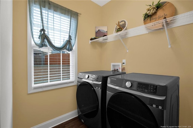 clothes washing area with laundry area, baseboards, separate washer and dryer, and dark wood-style flooring