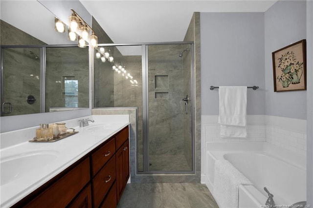 bathroom featuring double vanity, a stall shower, a garden tub, and a sink