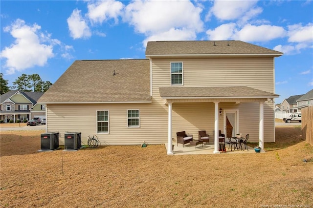 back of house featuring a patio area, a shingled roof, central AC unit, and a lawn