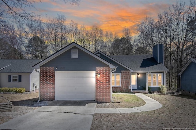 ranch-style home with a garage, driveway, a shingled roof, a chimney, and brick siding