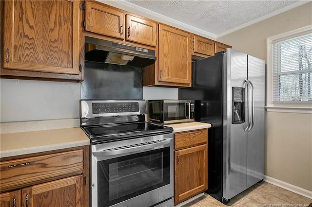 kitchen featuring stainless steel appliances, light countertops, under cabinet range hood, and a textured ceiling