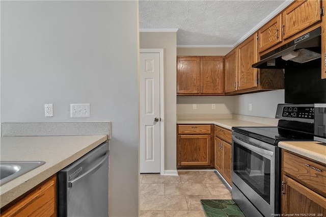 kitchen with stainless steel appliances, brown cabinets, light countertops, and under cabinet range hood