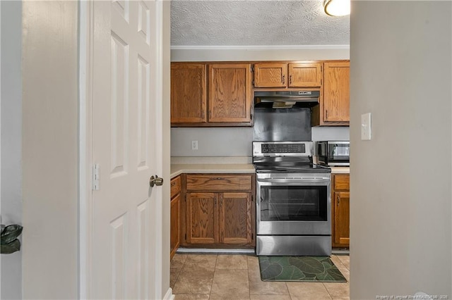 kitchen featuring brown cabinetry, stainless steel appliances, a textured ceiling, light countertops, and under cabinet range hood