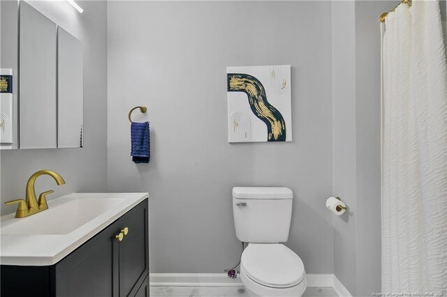 full bath featuring vanity, toilet, and baseboards