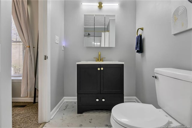 bathroom with vanity, toilet, and baseboards