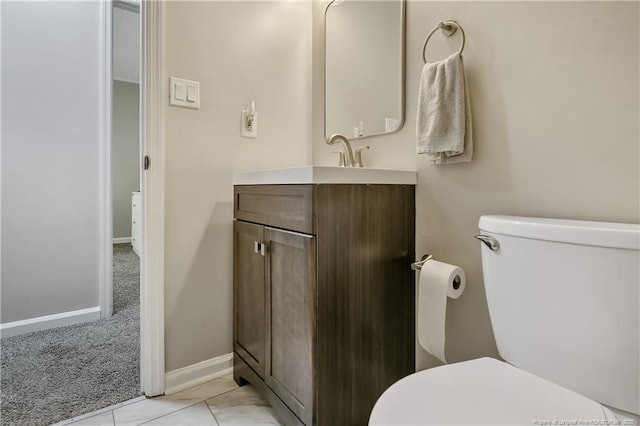 bathroom with baseboards, vanity, and toilet