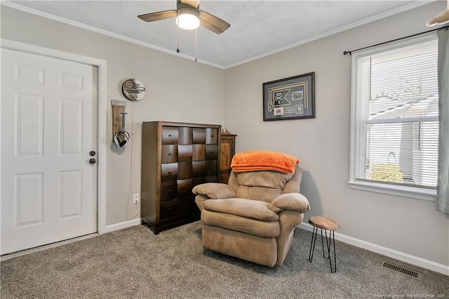 sitting room with carpet floors, baseboards, visible vents, and ornamental molding