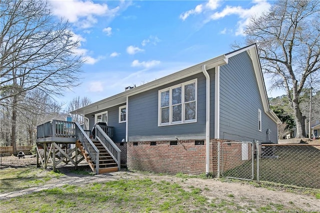 back of property featuring stairway, a gate, fence, and a wooden deck