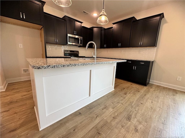 364 Whitestone Dr, Fayetteville, NC 28312 - kitchen with appliances with stainless steel finishes, light stone counters, light wood-type flooring, and decorative backsplash